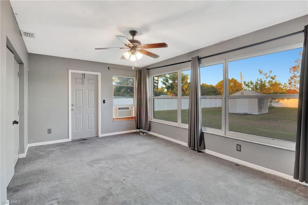 14 Illinois Road Lehigh Acres, FL 33936 - Photo 25 of 31 wooden floor in an empty room with a fireplace