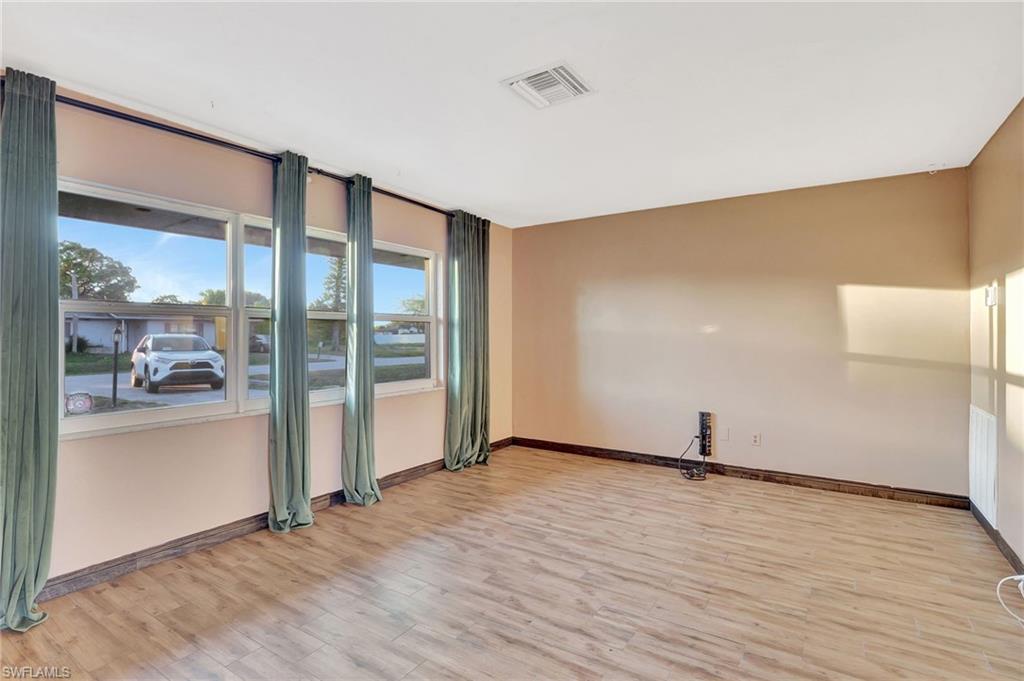 14 Illinois Road Lehigh Acres, FL 33936 - Photo 3 of 31 a view of an empty room with wooden floor and a window