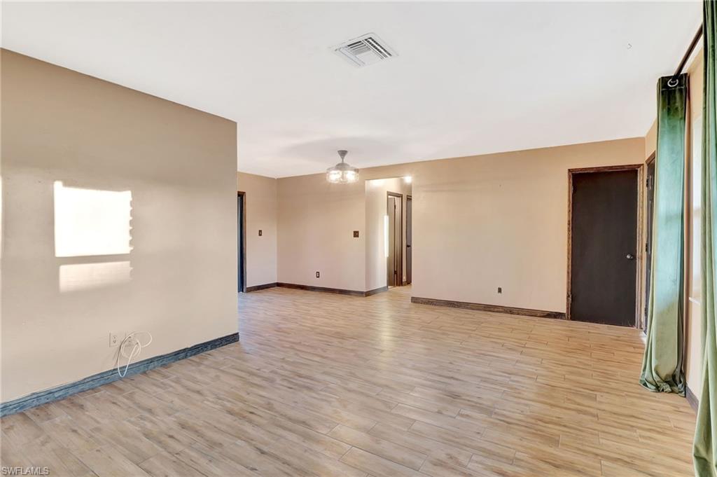 14 Illinois Road Lehigh Acres, FL 33936 - Photo 5 of 31 a view of an empty room with wooden floor and a window