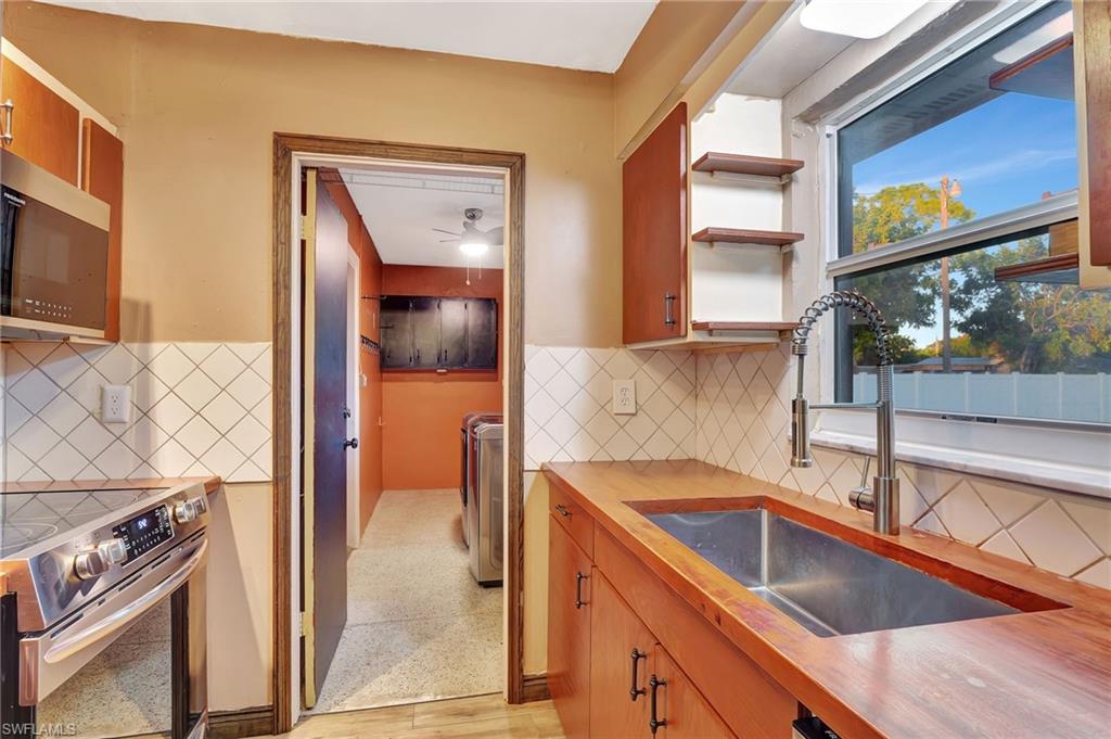 14 Illinois Road Lehigh Acres, FL 33936 - Photo 7 of 31 a kitchen that has a sink and a stove