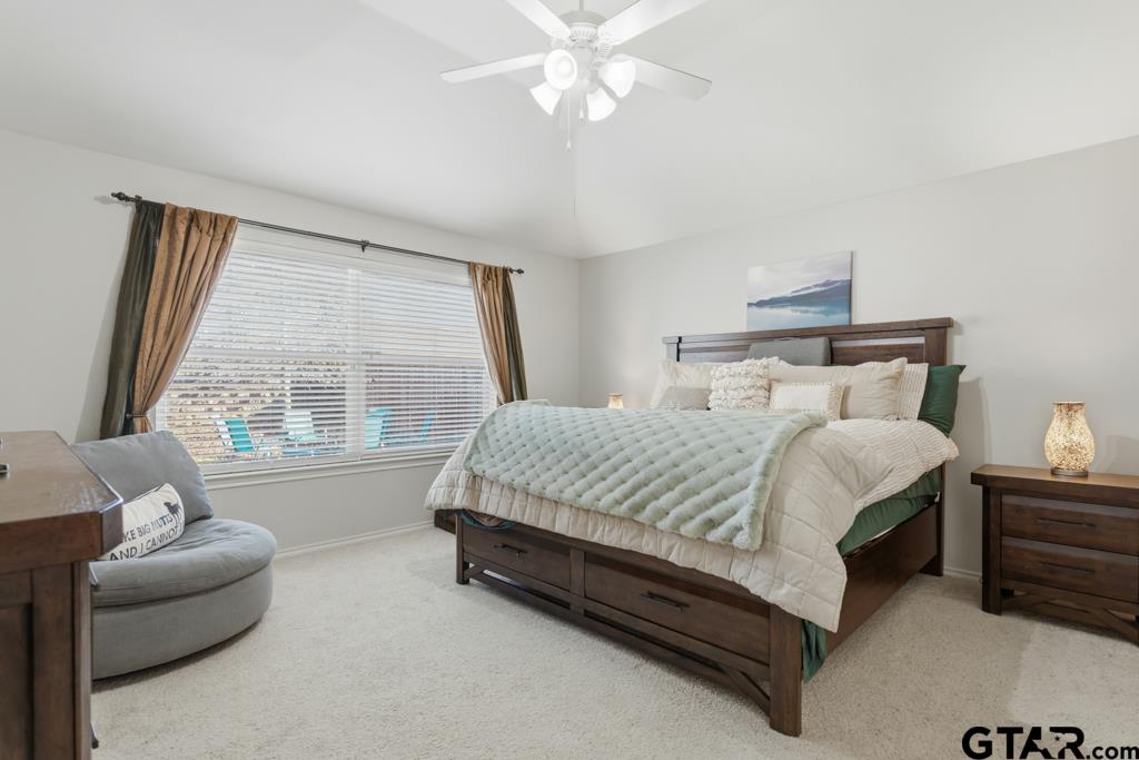 5821 Thompson Place Tyler, TX 75707 - Photo 18 of 34 a spacious bedroom with a bed and a couch