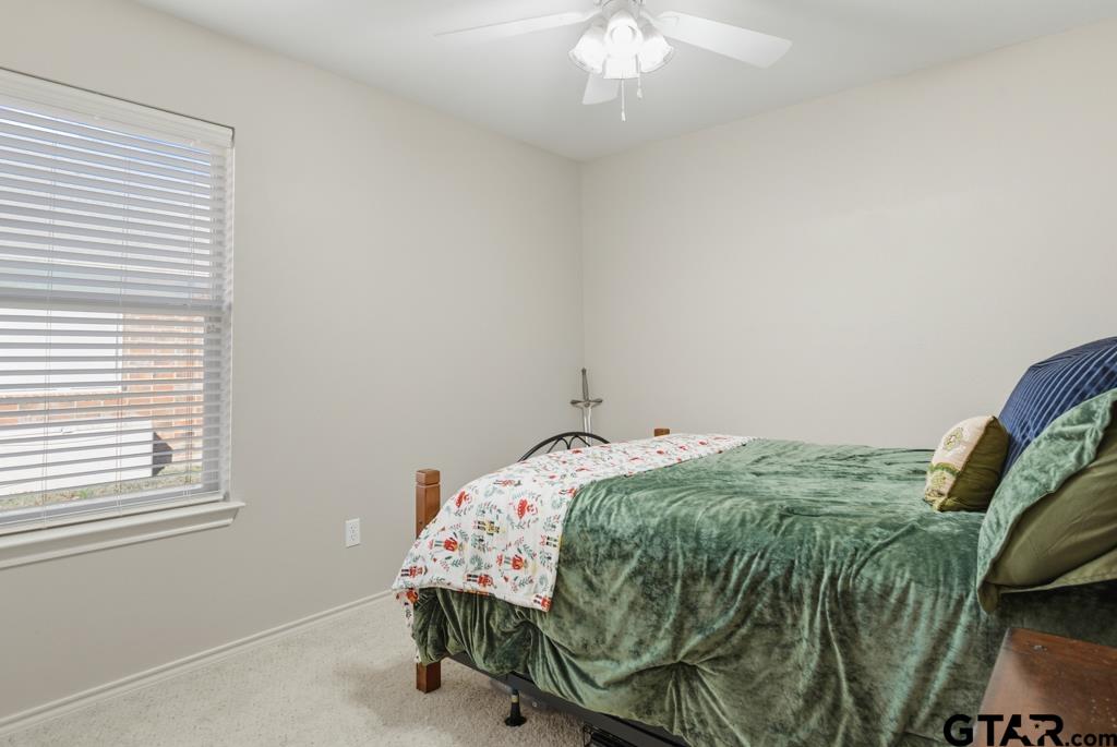5821 Thompson Place Tyler, TX 75707 - Photo 24 of 34 a bedroom with a bed and a chandelier