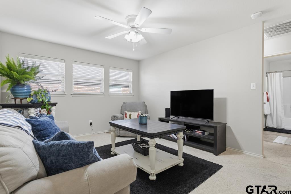 5821 Thompson Place Tyler, TX 75707 - Photo 25 of 34 a living room with furniture and a flat screen tv