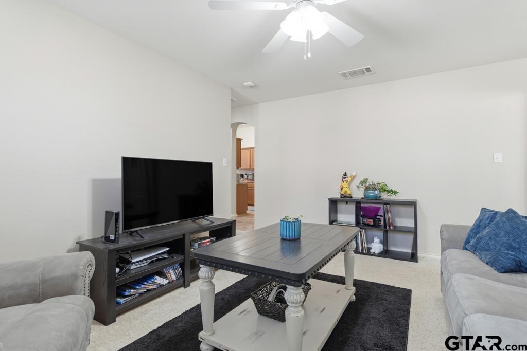 5821 Thompson Place Tyler, TX 75707 - Photo 26 of 34 a living room with furniture and a flat screen tv