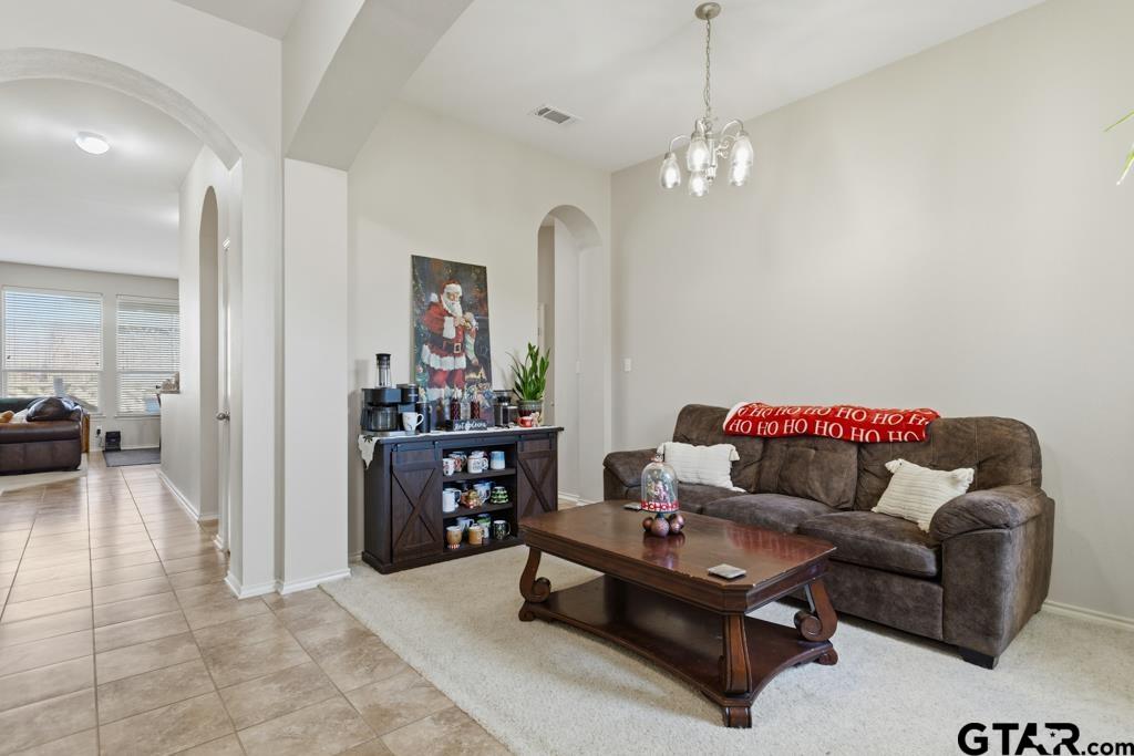 5821 Thompson Place Tyler, TX 75707 - Photo 5 of 34 a living room with furniture and a chandelier