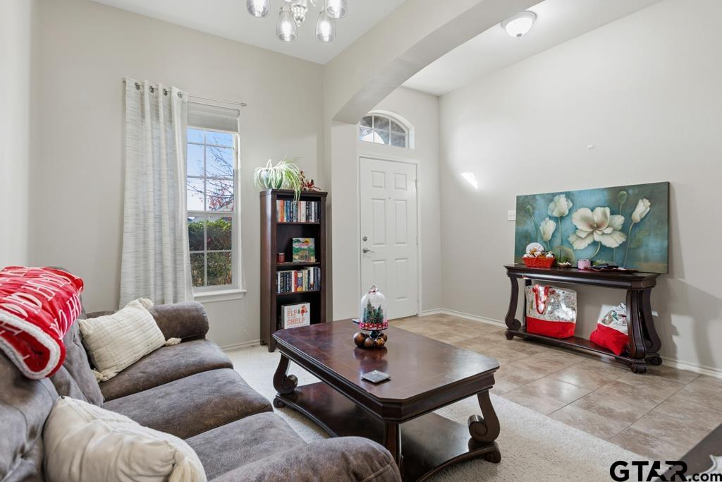 5821 Thompson Place Tyler, TX 75707 - Photo 7 of 34 a living room with furniture a flat screen tv and a wall painting