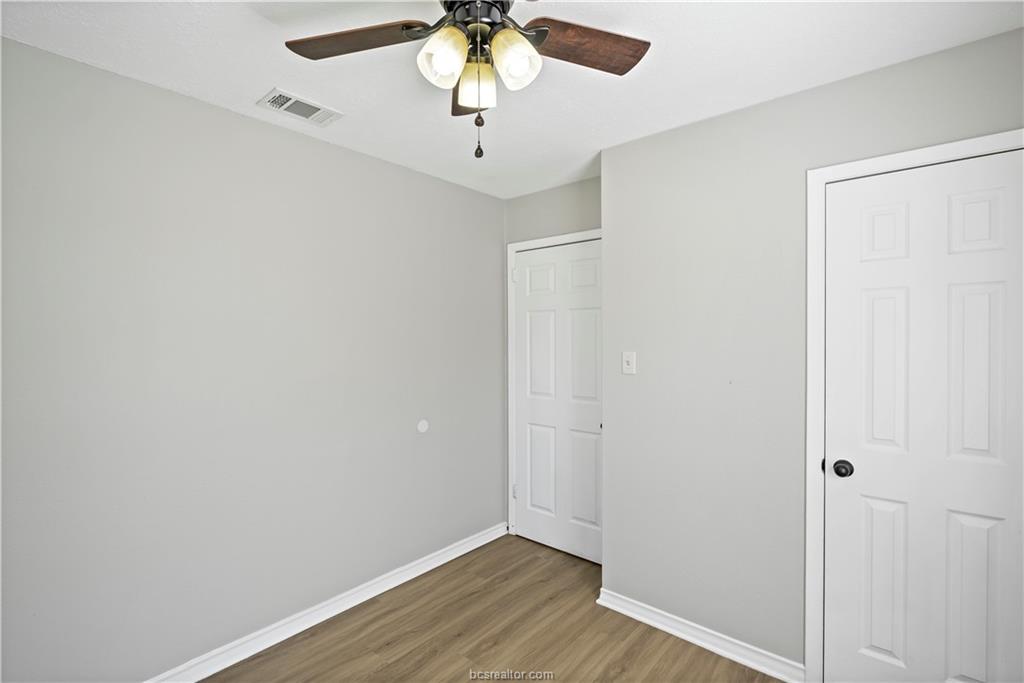 1907 Orman Street Bryan, TX 77801 - Photo 16 of 20 an empty room with a chandelier fan and wooden floor