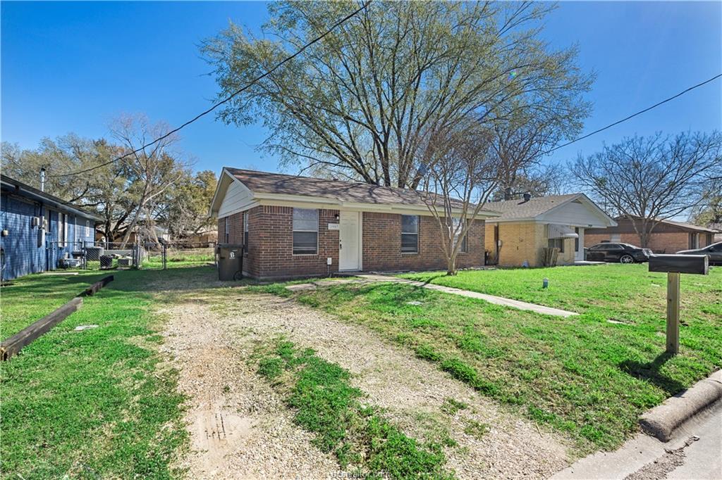 1907 Orman Street Bryan, TX 77801 - Photo 3 of 20 a brick house next to a yard with large trees