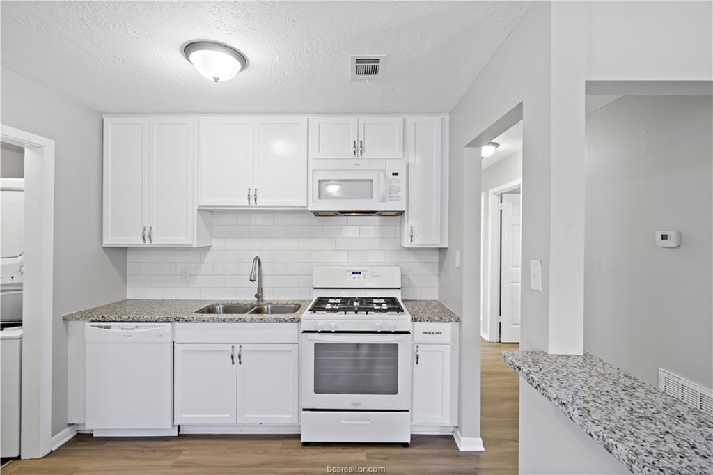 1907 Orman Street Bryan, TX 77801 - Photo 8 of 20 a kitchen with granite countertop white cabinets and appliances