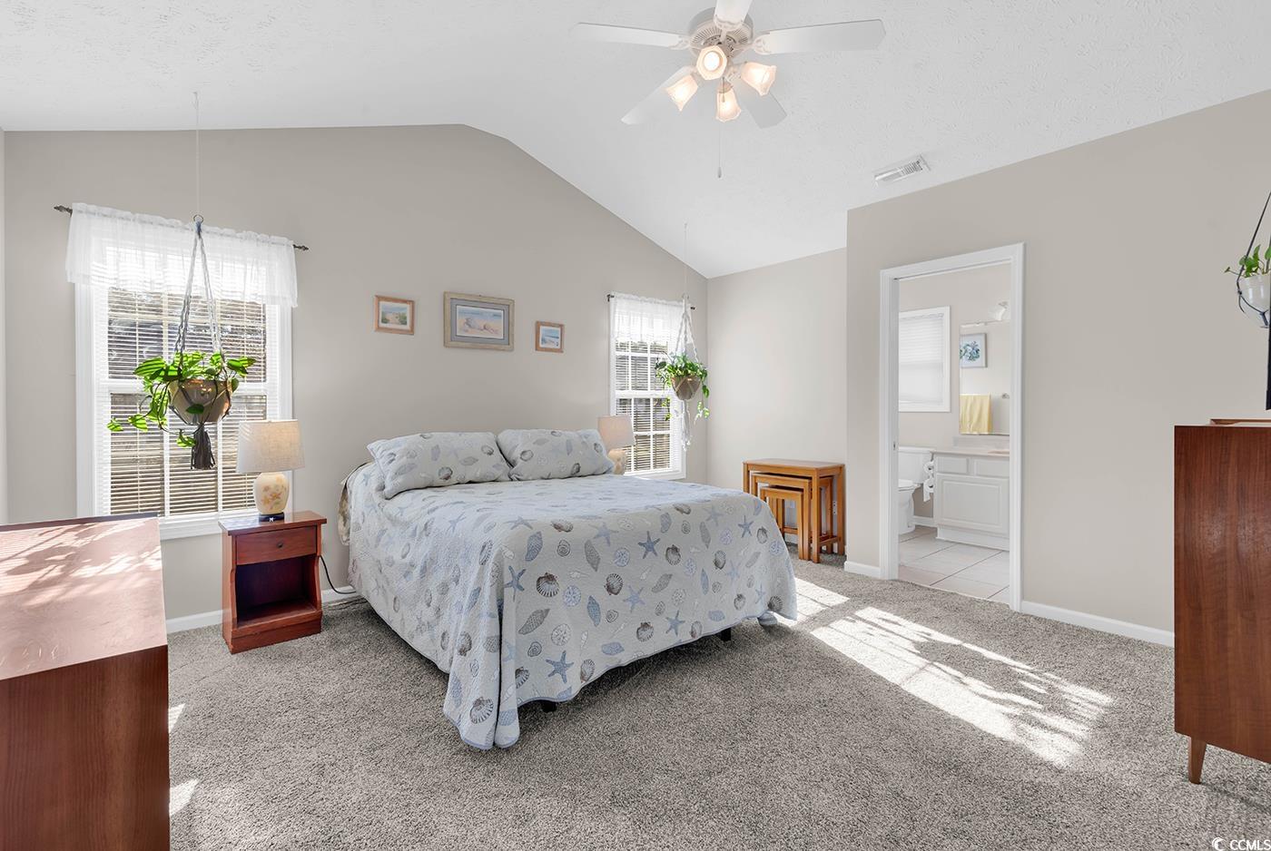 653 Pamlico Court Myrtle Beach, SC 29588 - Photo 17 of 39 Bedroom featuring light colored carpet, lofted ceiling, a ceiling fan, and ensuite bath