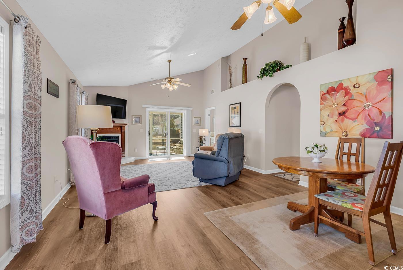 653 Pamlico Court Myrtle Beach, SC 29588 - Photo 2 of 39 Living area featuring arched walkways, wood finished floors, ceiling fan, a fireplace, and high vaulted ceiling