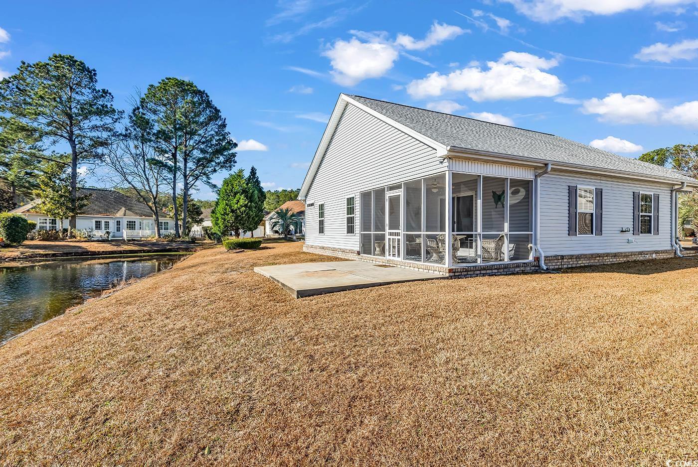 653 Pamlico Court Myrtle Beach, SC 29588 - Photo 34 of 39 Rear view of property featuring a sunroom, a patio, roof with shingles, and a lawn