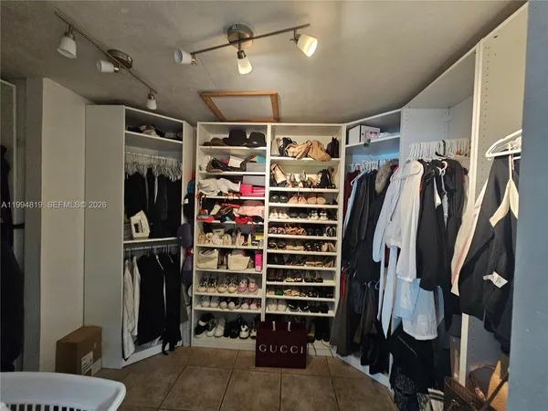 a view of walk in closet with clothes and shoes
