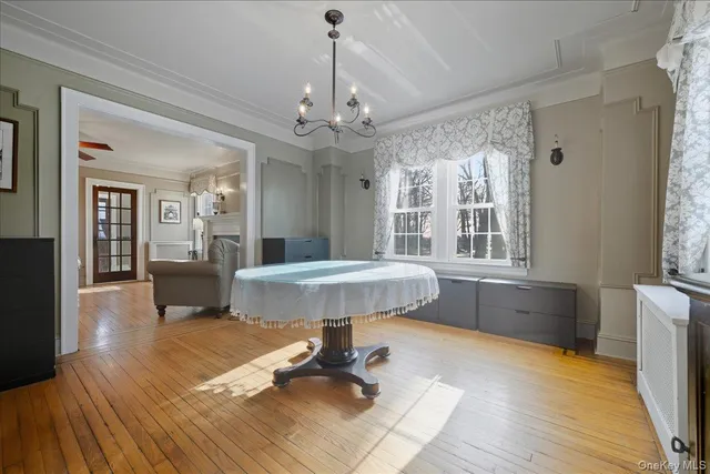 a view of a room with a chandelier and wooden floor