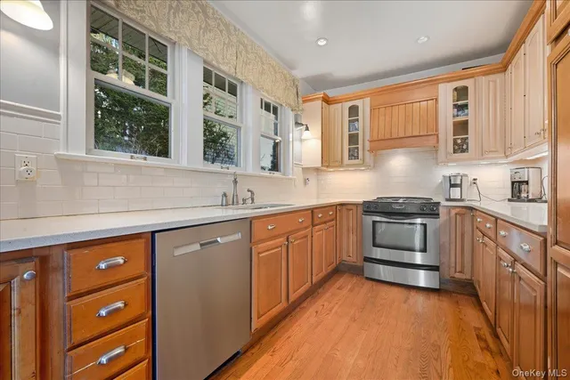 a kitchen with stainless steel appliances granite countertop a sink and wooden cabinets