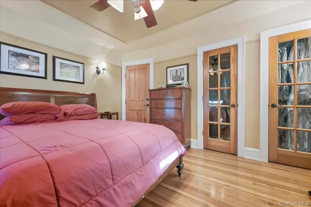 a bedroom with a bed a chandelier and dresser