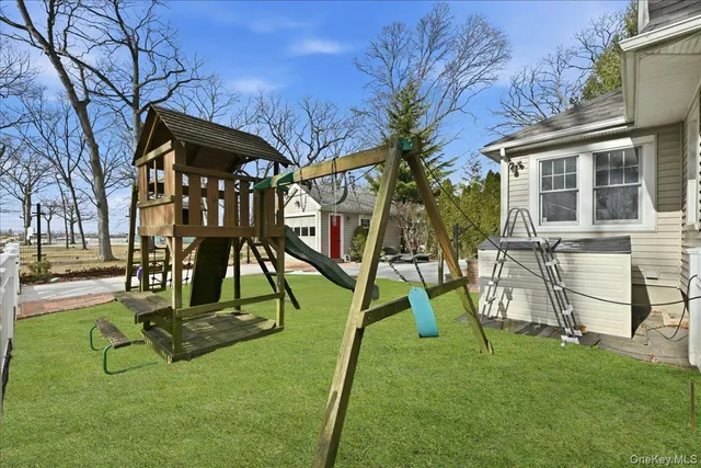 a view of a patio with table and chairs and a barbeque with potted plants and large trees