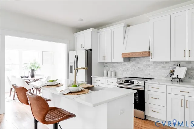 a kitchen with a sink a stove and white cabinets