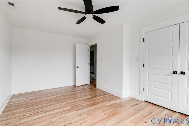 a view of empty room with wooden floor
