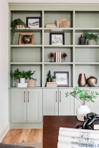 a living room with white cabinets and a wooden floor