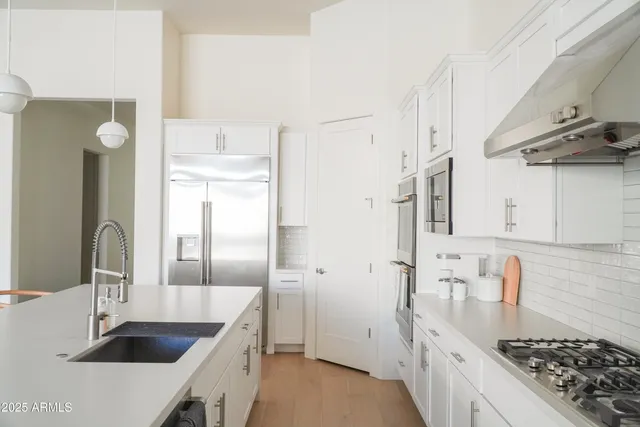a kitchen with stainless steel appliances a sink a stove and a refrigerator