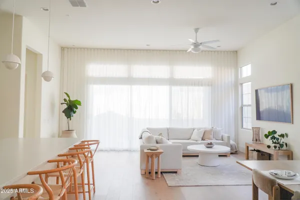 a living room with furniture a chandelier and a dining table