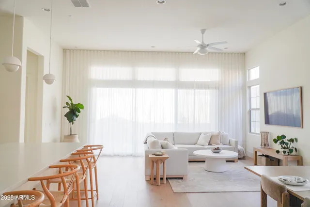 a living room with furniture a chandelier and a dining table