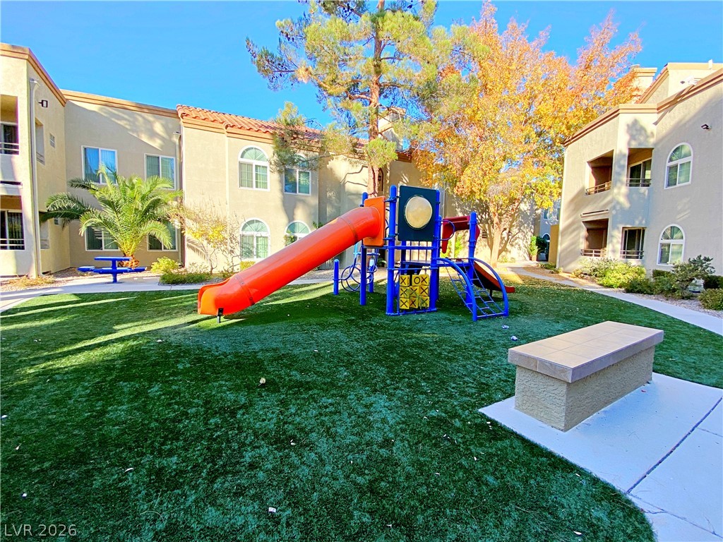 3145 East Flamingo Road, Unit 1128 Las Vegas, NV 89121 - Photo 18 of 19 A vibrant playground set amidst green turf, inviting fun in a community setting.