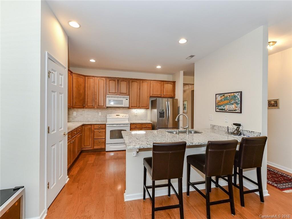 389 Garnet Court Fort Mill, SC 29708 - Photo 12 of 29 a kitchen with stainless steel appliances kitchen island granite countertop a dining table chairs and a refrigerator