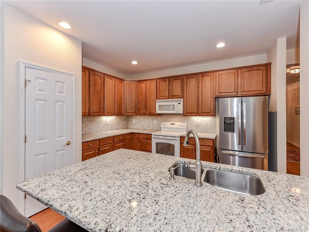 389 Garnet Court Fort Mill, SC 29708 - Photo 13 of 29 a kitchen with stainless steel appliances granite countertop a sink refrigerator and cabinets