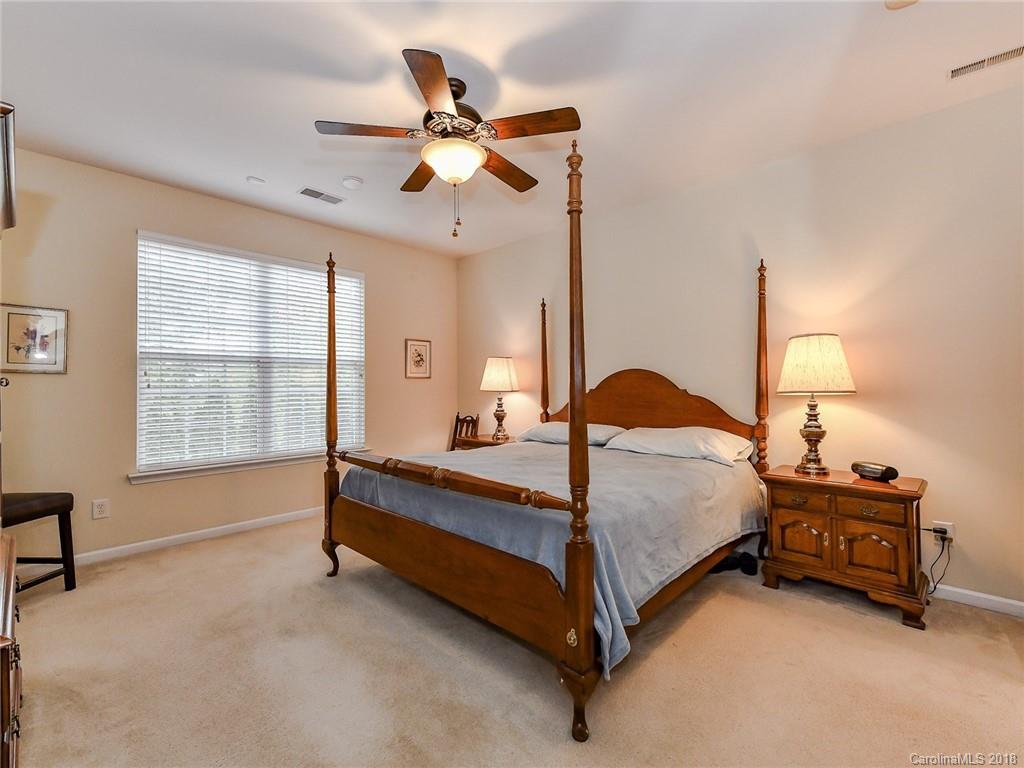 389 Garnet Court Fort Mill, SC 29708 - Photo 20 of 29 a spacious bedroom with a bed and a chandelier