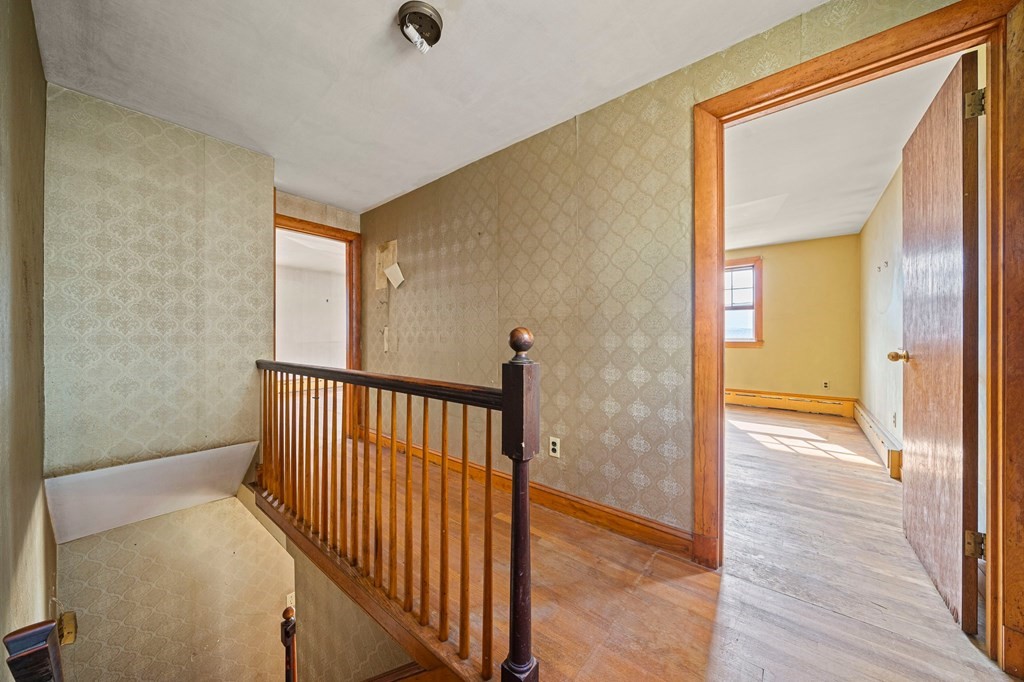 16 Magdala Street Boston, MA 02124 - Photo 18 of 22 a view of a hallway with wooden floor and staircase