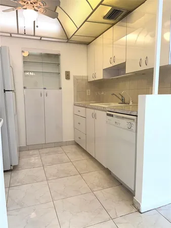 a kitchen with a sink a stove and cabinets