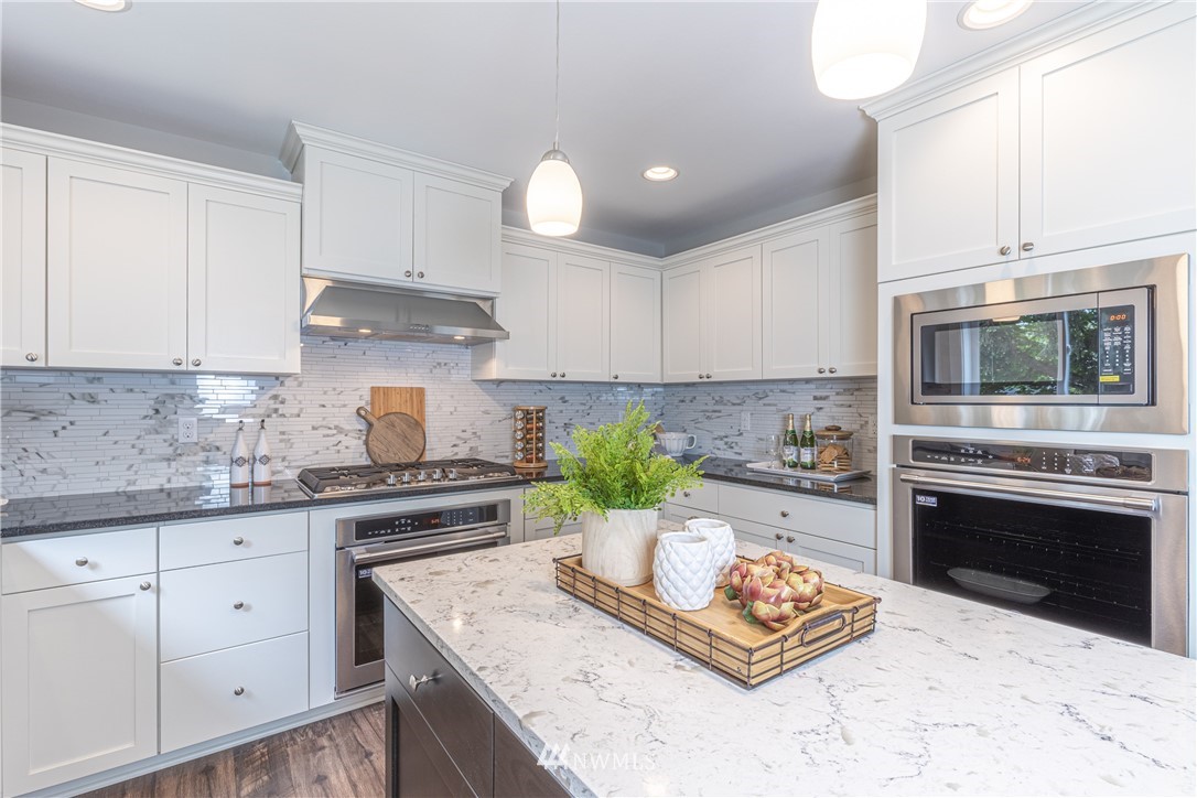 613 Index Avenue Northeast Renton, WA 98056 - Photo 11 of 32 a kitchen with stainless steel appliances kitchen island granite countertop a sink stove and cabinets