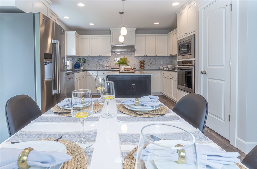 613 Index Avenue Northeast Renton, WA 98056 - Photo 13 of 32 a kitchen with stainless steel appliances granite countertop a dining table and chairs