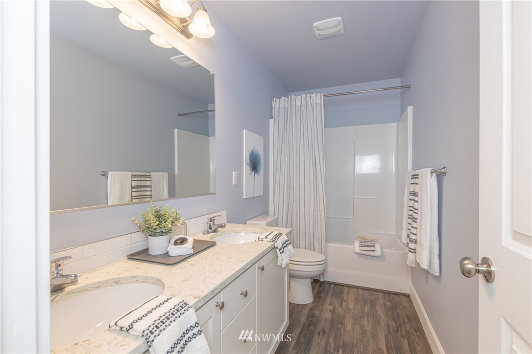 613 Index Avenue Northeast Renton, WA 98056 - Photo 18 of 32 a bathroom with a granite countertop sink a toilet and shower