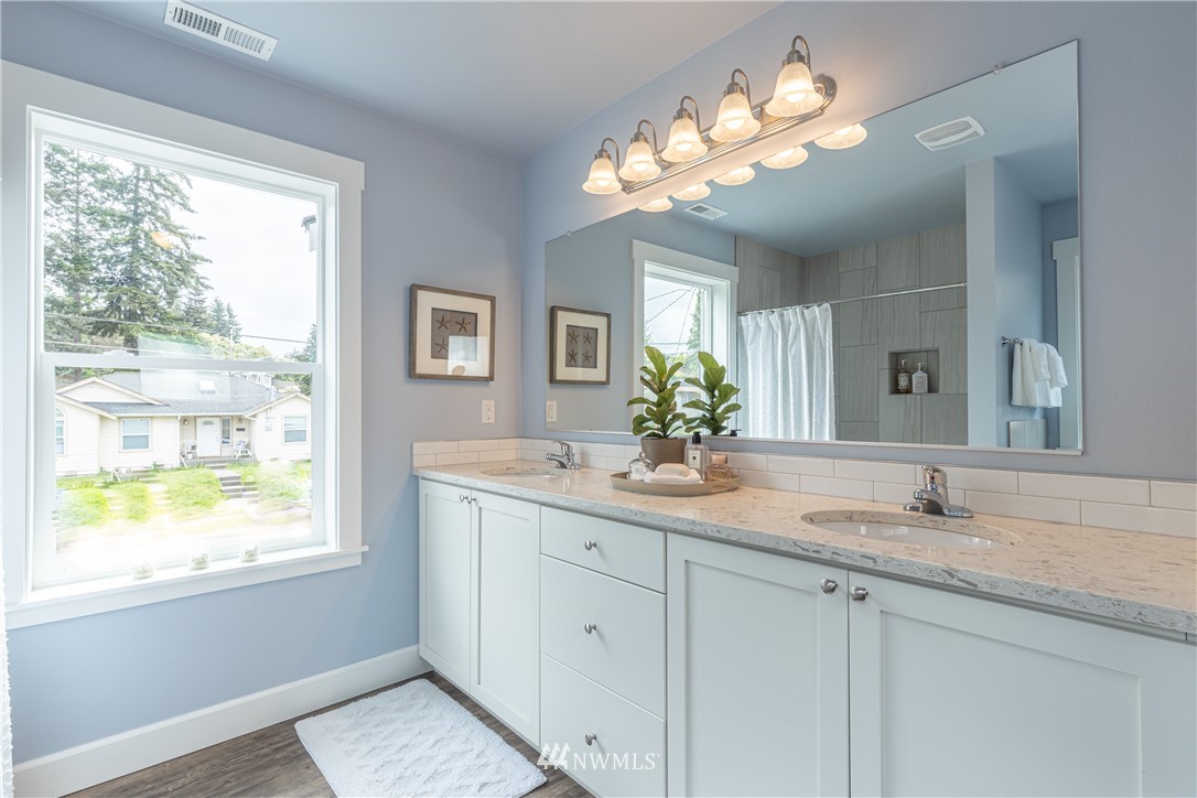 613 Index Avenue Northeast Renton, WA 98056 - Photo 24 of 32 a bathroom with a granite countertop sink a large mirror a and a window