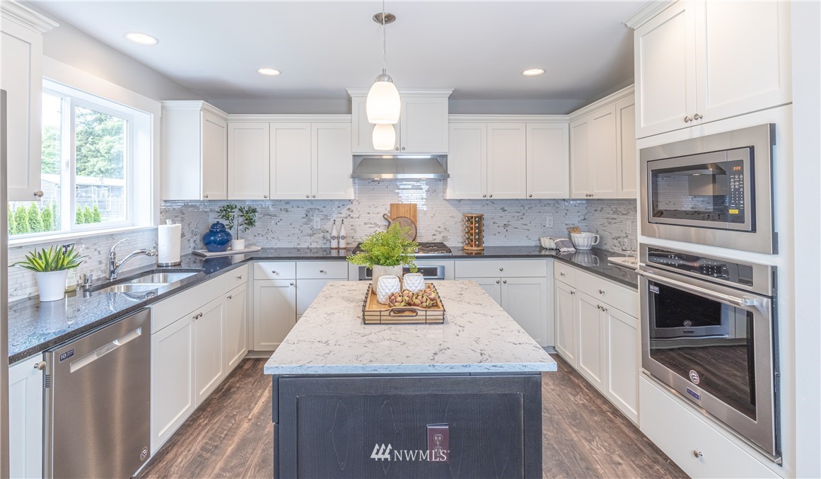 613 Index Avenue Northeast Renton, WA 98056 - Photo 7 of 32 a kitchen with granite countertop kitchen island stainless steel appliances a stove sink and cabinets