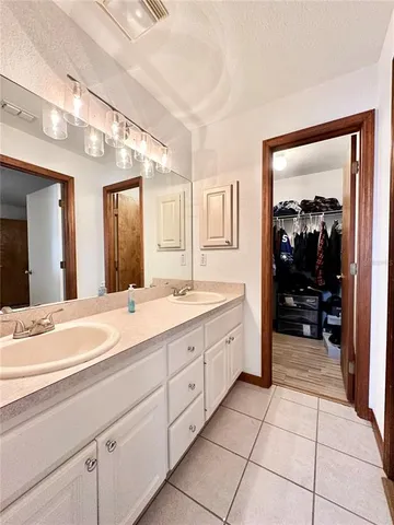 a spacious bathroom with a granite countertop sink mirror and cabinets