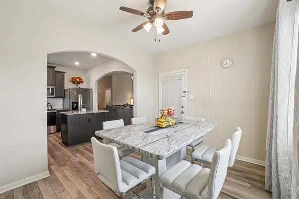 a view of a dining room with furniture and a chandelier fan
