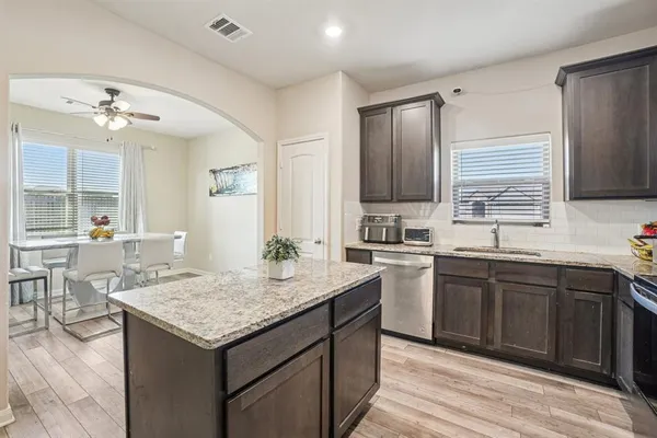 a kitchen with a stove center island cabinets and wooden floor