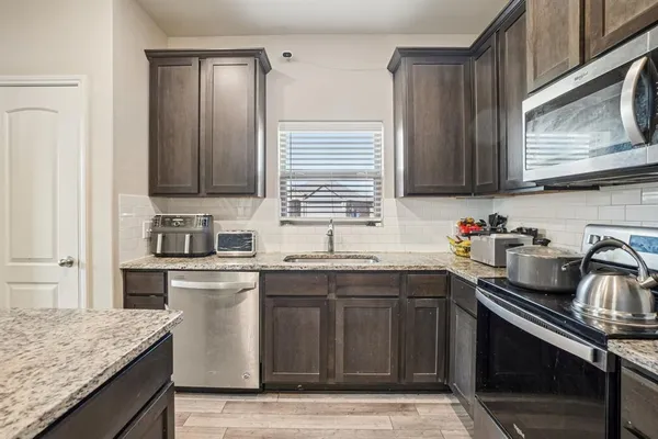 a kitchen with a sink stove top oven and cabinets