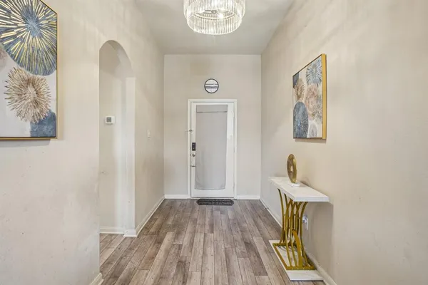 a view of a hallway with wooden floor and a potted plant