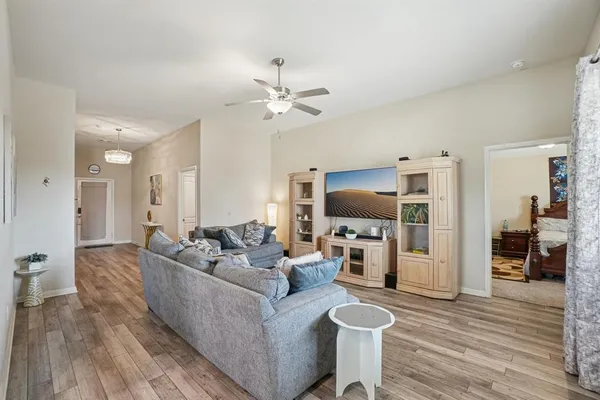 a living room with furniture flat screen tv and wooden floor