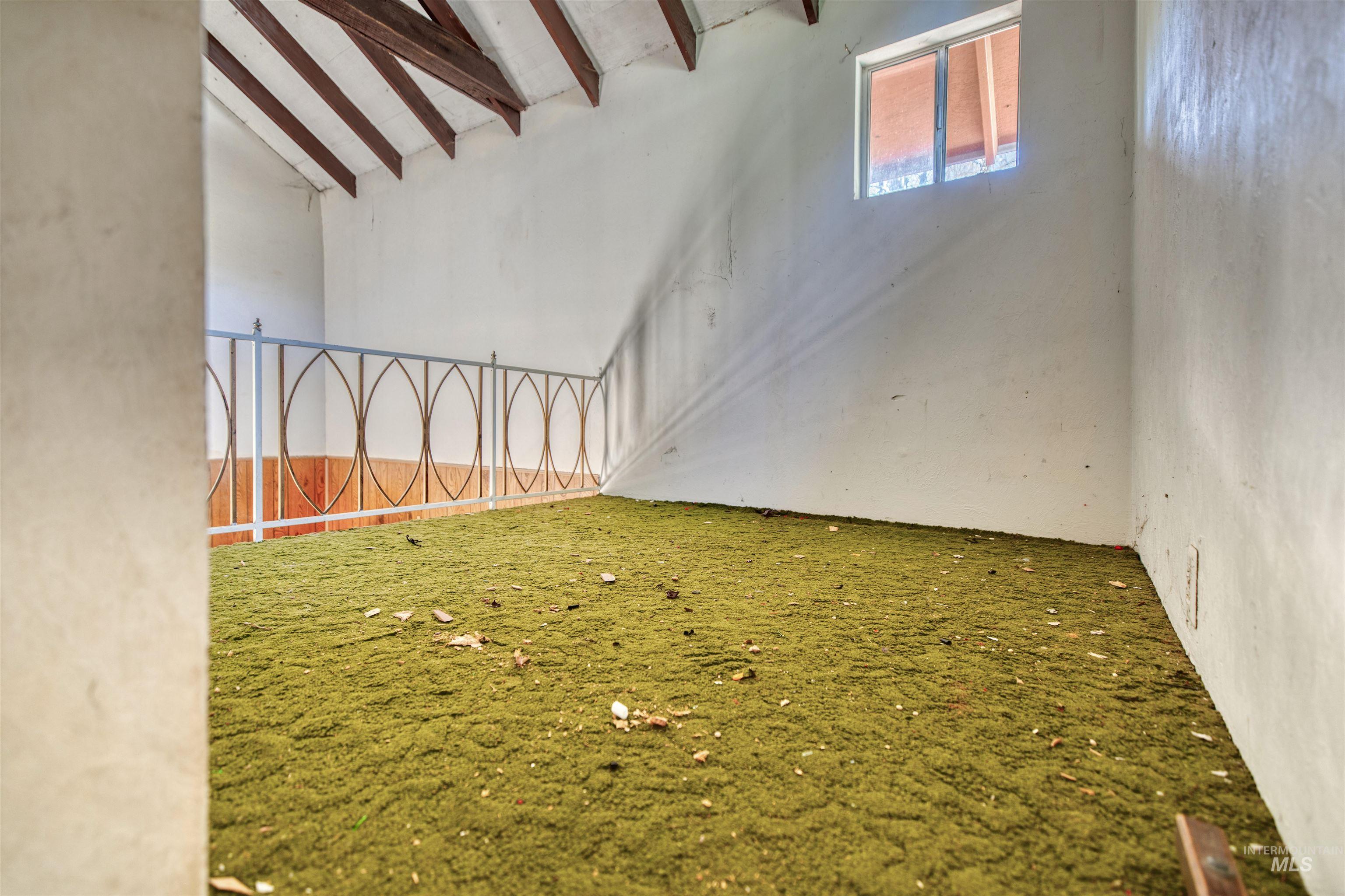 175 Ranft Road Placerville, ID 83666 - Photo 12 of 28 Empty room with carpet flooring and vaulted ceiling with beams