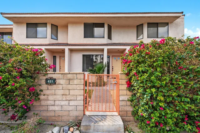 a front view of house and yard with beautiful flowers and entertaining space