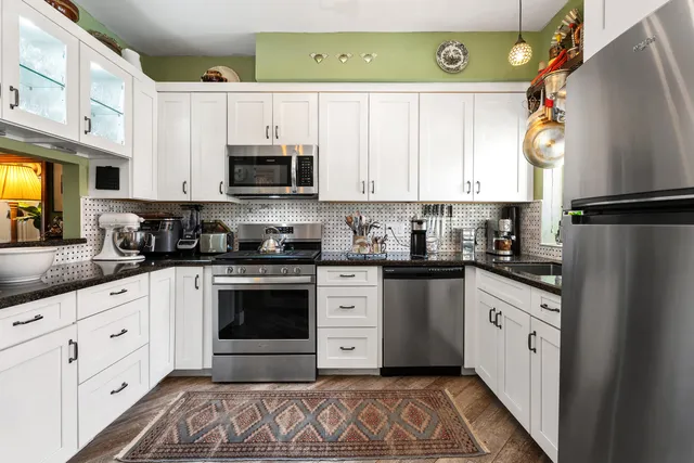 a kitchen with granite countertop a white stove top oven and sink