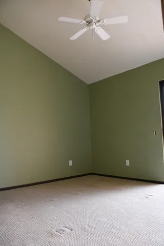 an empty room with a ceiling fan and a window