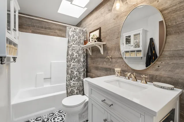 a bathroom with a sink toilet a mirror and shower