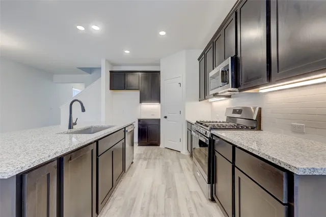 a kitchen with granite countertop stainless steel appliances and cabinets
